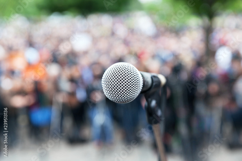 Microphone in focus against blurred protest or public demonstration