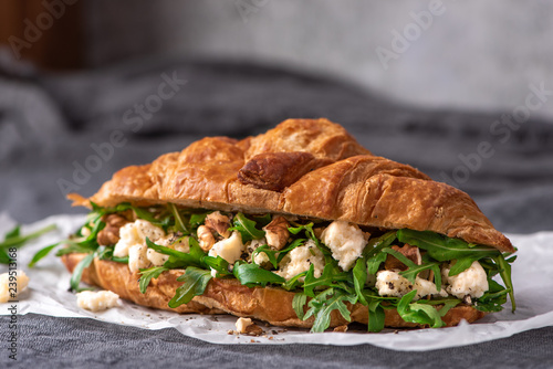 Delicious sandwich. Croissant with arugula, goat cheese and walnuts.