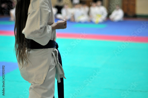 Kids of karate. Training and exam in karate. Teen girl demonstrates kata.