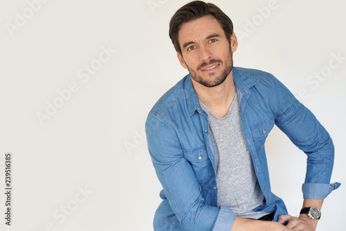 Very handsome casual man sitting on white background photo