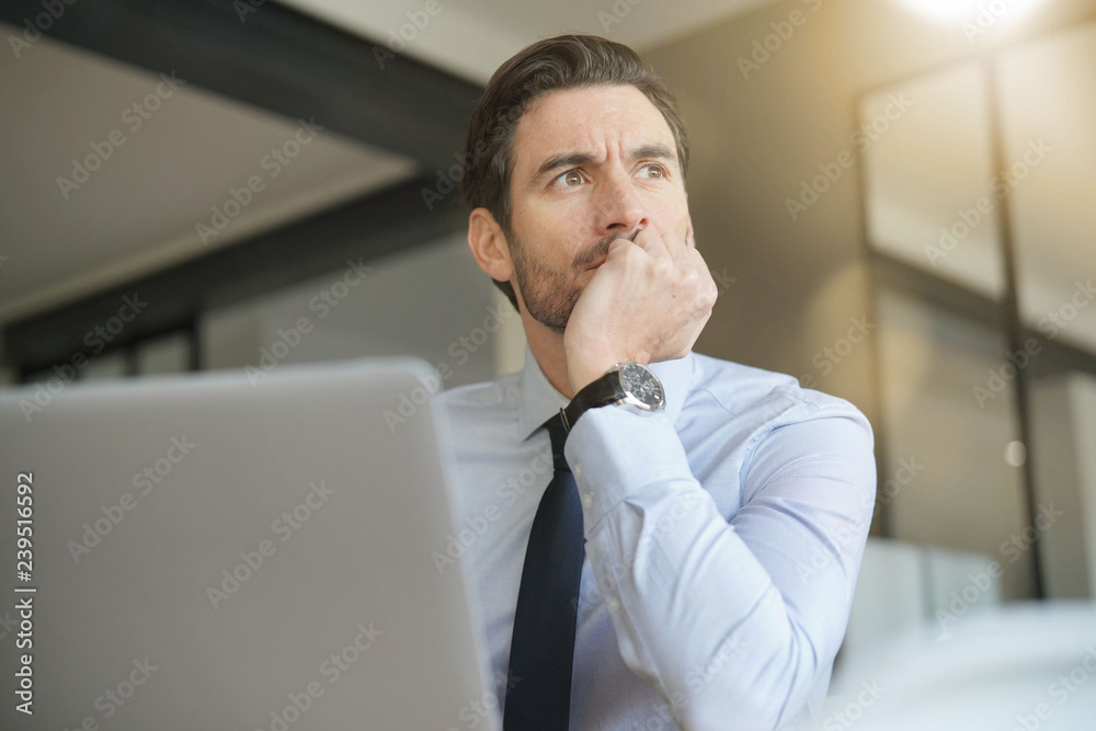 © goodluz - Handsome businessman in modern office looking out © goodluz - Handsome businessman in modern office looking out