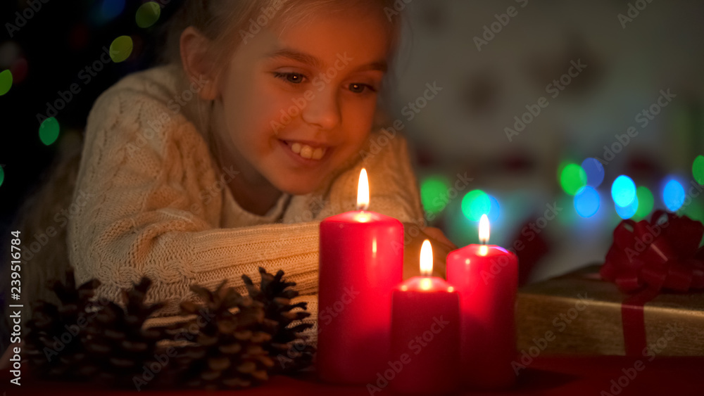 Dreamy girl enjoying view at burning candles, waiting for X-mas celebration Dreamy girl enjoying view at burning candles, waiting for X-mas celebration
