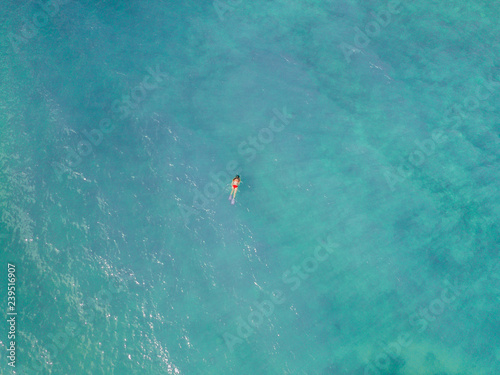 top shot of a girl swimming in the blue ocean