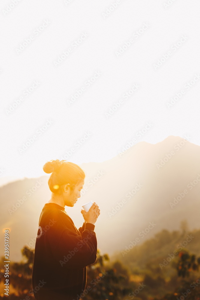 Asian Woman Standing drinking coffee and relaxing in sunrise and sunshine light enjoying life her warm morning, Lifestyle Concept