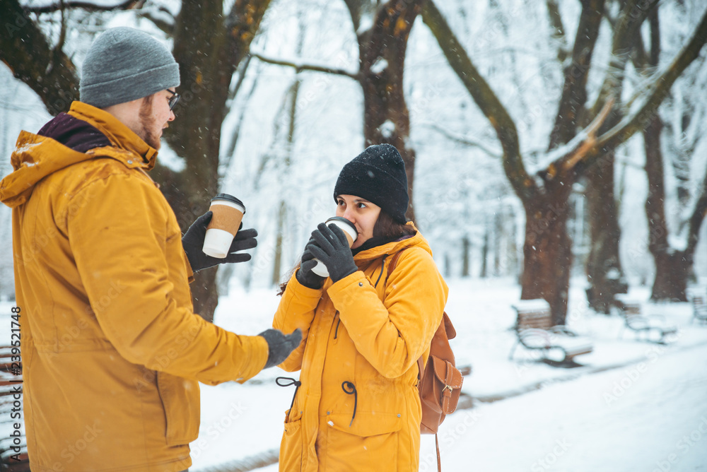 couple walking by snowed city park talking socializing. romantic date in winter time