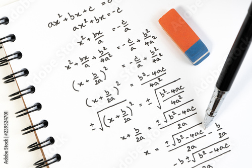 Handwriting of mathematics quadratic equation formula on examination, practice, quiz or test in maths class. Solving exponential equations background concept.