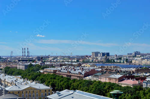 Panorama of the city from above. With pipes and construction cranes in the background.