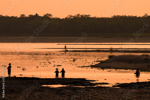 Asian women fishing in the river, silhouette at sunset