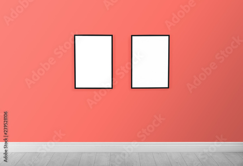 Frames with empty canvases on wall in modern art gallery. Mockup for design