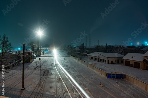 Railway tracks covered with snow at night