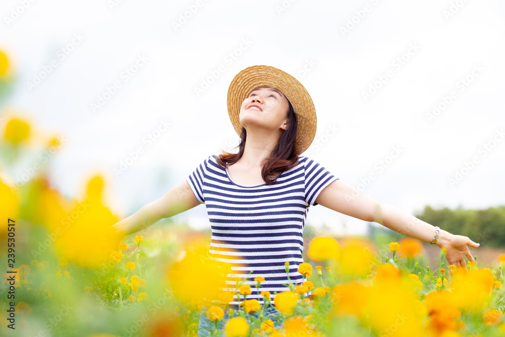Beautiful Asian women wearing a hat looking forward standing in the meadow field close up.