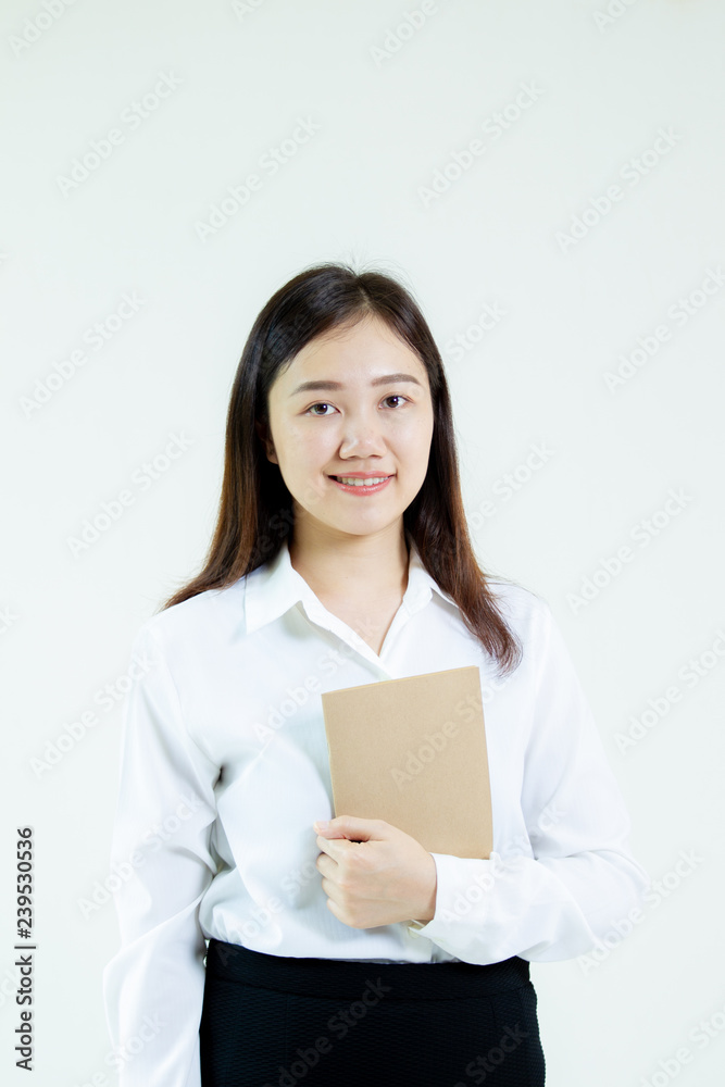 Portrait of a pretty young Asian student in formal white shirt holding a note book on hand on white background. Portrait of a pretty young Asian student in formal white shirt holding a note book on hand on white background.