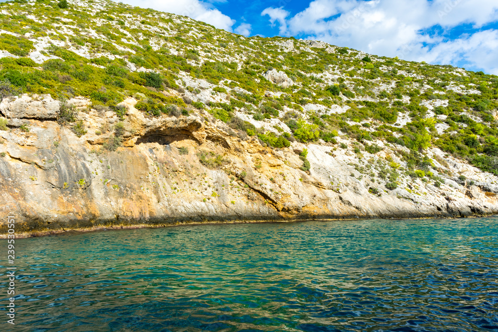 Greece, Zakynthos, Porto Limnionas bay and green plants covering rocky mountains