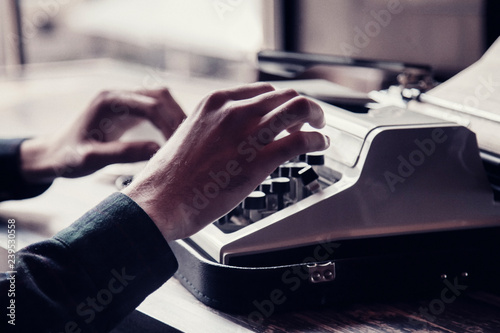 Close up man typing on an antique vintage typewriter machine © zwiebackesser