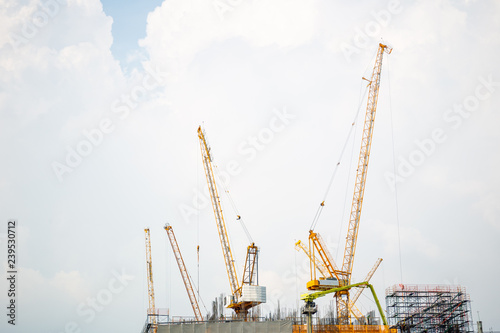 Photograh showing a high building is under construction with heavy tower crane. photo