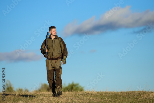 Hunting hobby. Guy hunting nature environment. Masculine hobby activity. Hunting weapon gun or rifle. Man hunter carry rifle blue sky background. Experience and practice lends success hunting