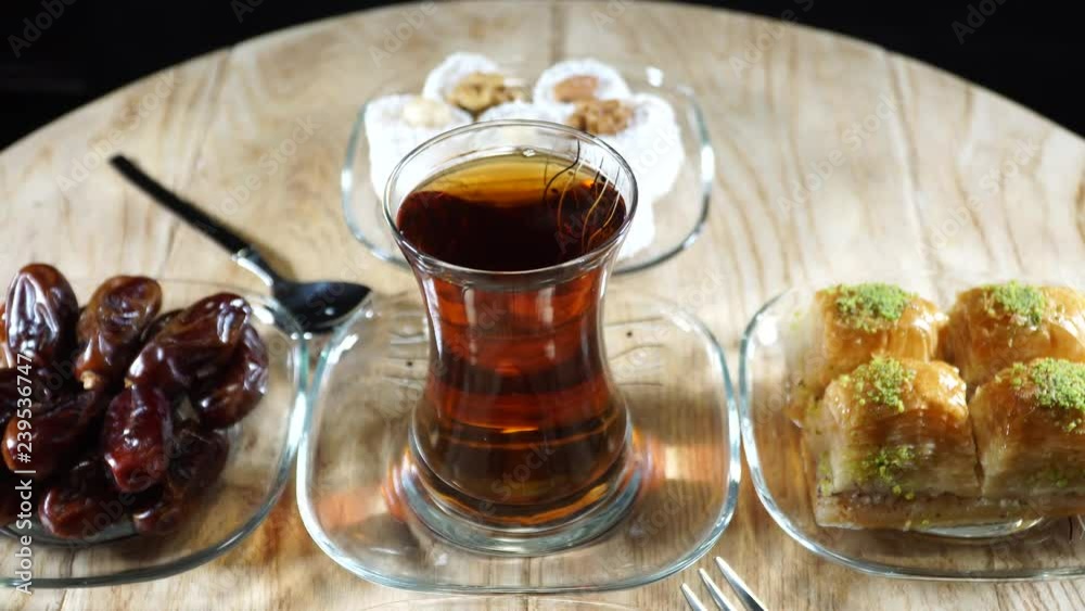 Turkish tea and flavors together. Turkish delight, cherry jam, dates, baklava. 4K Turkish tea and flavors together. Turkish delight, cherry jam, dates, baklava. 4K