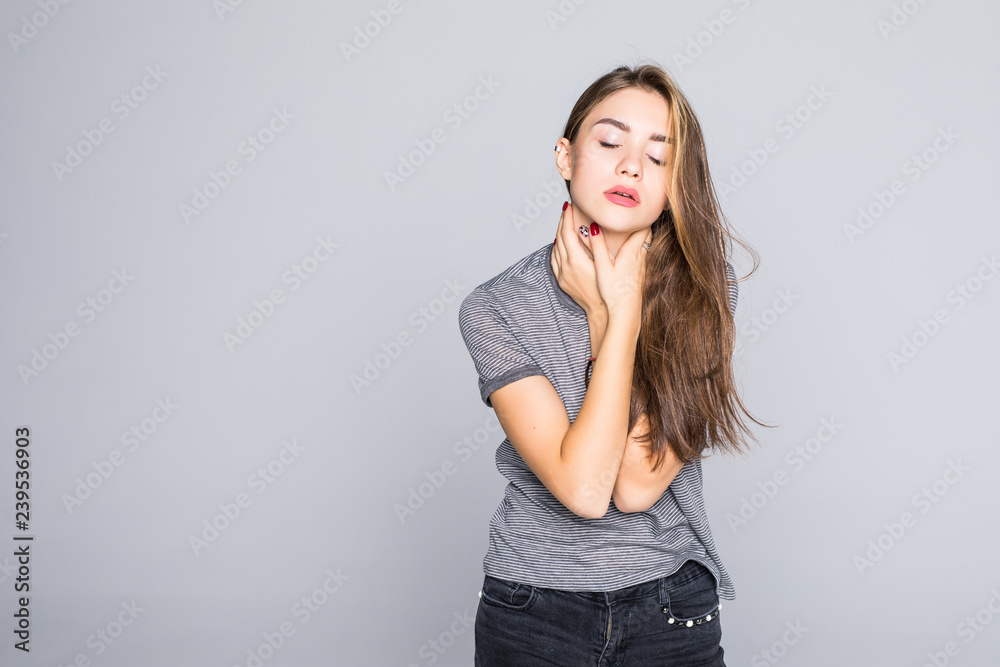 Back and spine disease. Closeup portrait tired woman massaging her painful neck isolated on gray wall background. Face expression Back and spine disease. Closeup portrait tired woman massaging her painful neck isolated on gray wall background. Face expression