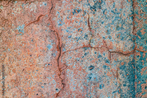 an old painted wall with pealing blue and orange paint