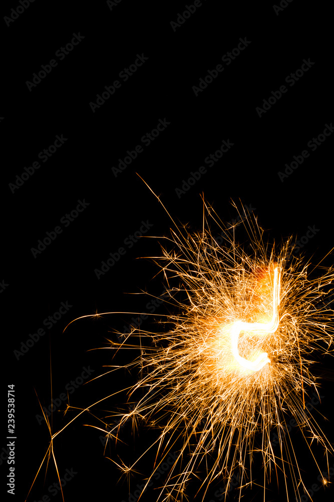 Bright burning Christmas sparkler on black background