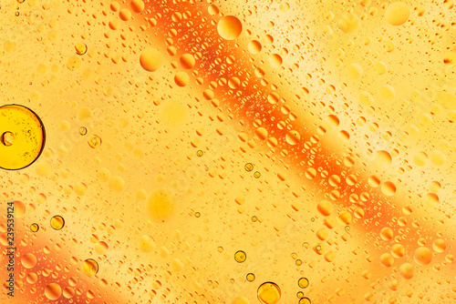 water drops on glass with orange background, close-up 