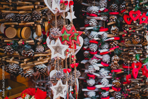 Festive decorations handmade of natural sticks and bumps. Wooden garlands in rustic style hanging on Christmas market.