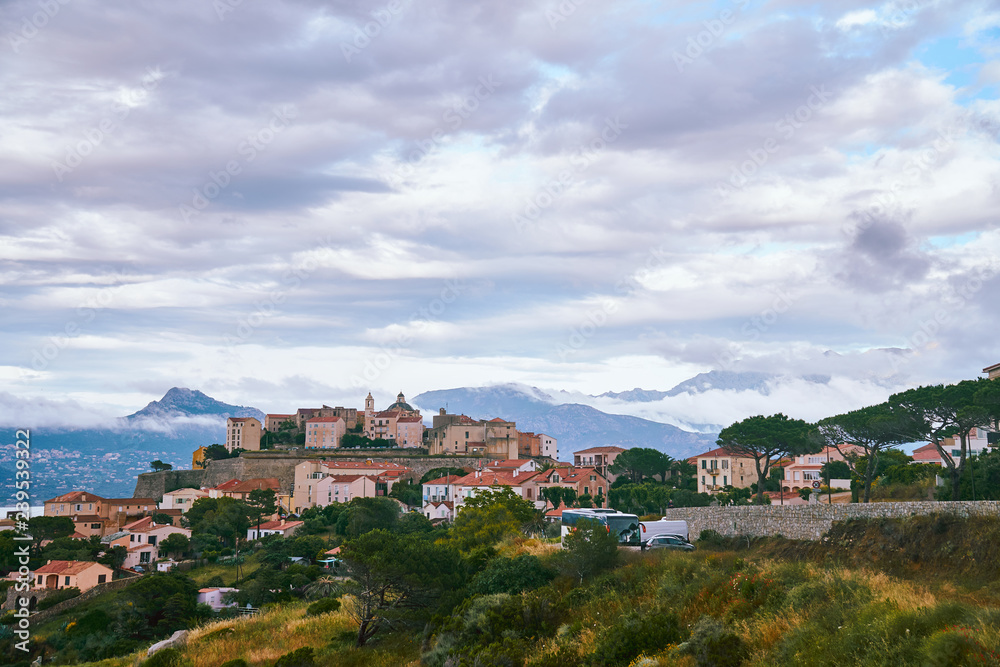 View of Citadel of Calvi during the cloudy day with mountains in the background