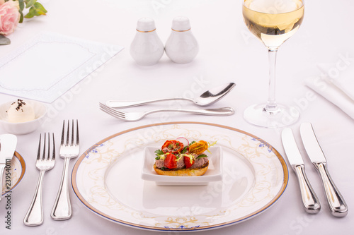 Bruschetta with vegetables, is served with a glass of white wine