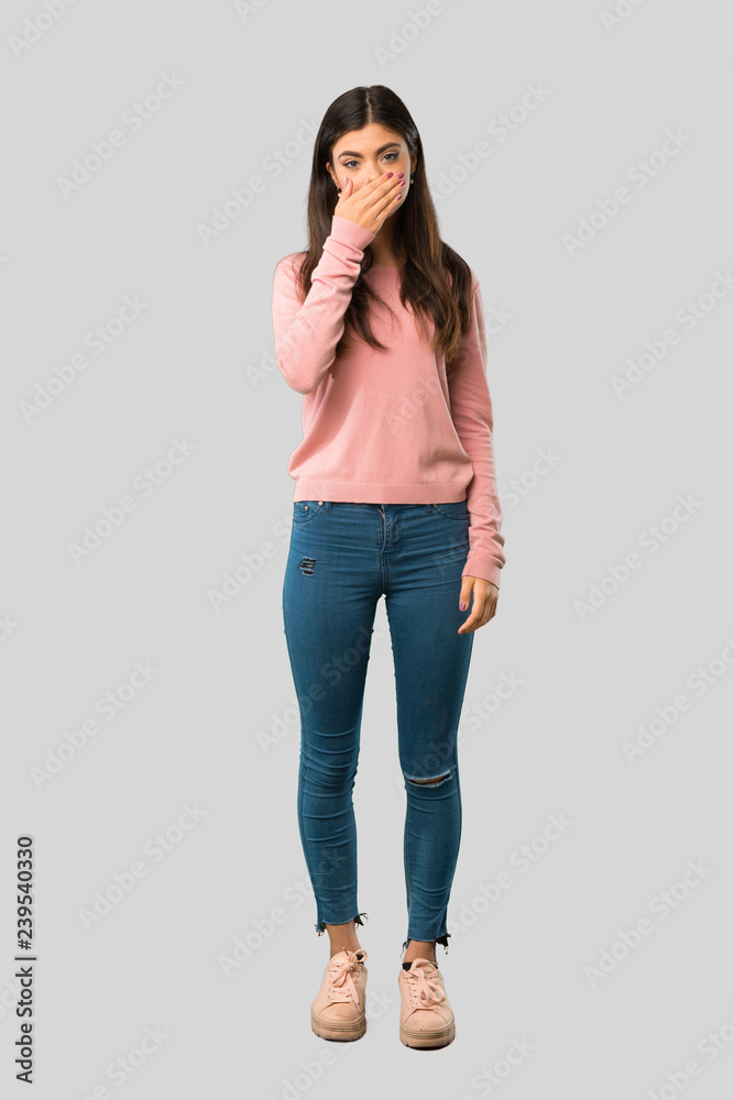 Full body of Teenager girl with pink shirt covering mouth with hands for saying something inappropriate on isolated grey background Full body of Teenager girl with pink shirt covering mouth with hands for saying something inappropriate on isolated grey background