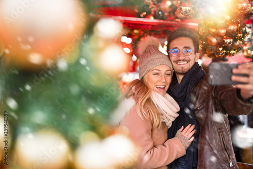 A young couple do a selfie in the decorated street for Christmas