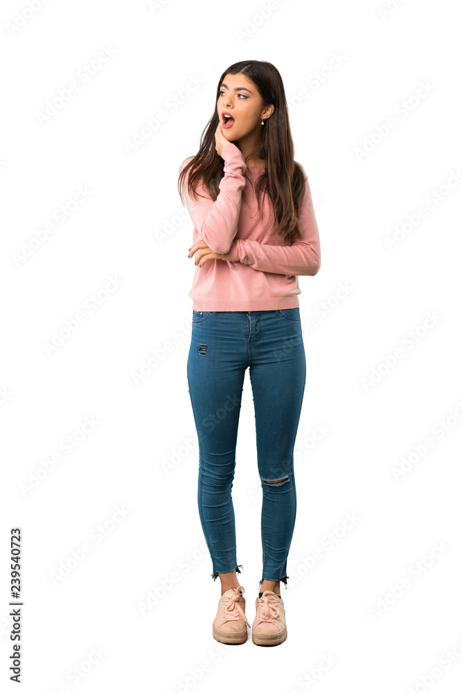 Fototapeta premium A full-length shot of a Teenager girl with pink shirt surprised and shocked while looking right