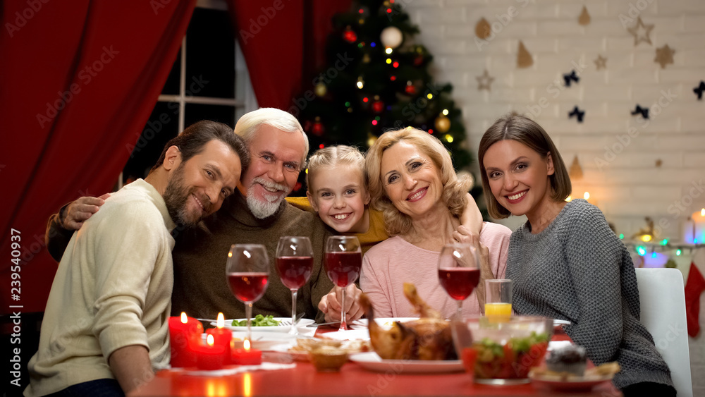 Big family hugging, smiling and looking to camera at Christmas dinner, portrait Big family hugging, smiling and looking to camera at Christmas dinner, portrait