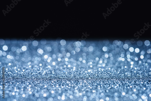 selective focus of blurred sparkling surface on black