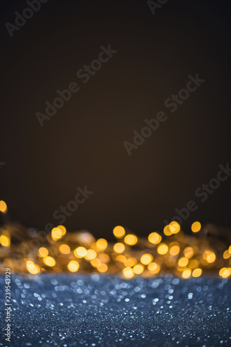 selective focus of blurred sparkling lights and bokeh on black