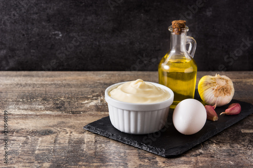 Aioli sauce and ingredients on wooden table. Copyspace

 photo