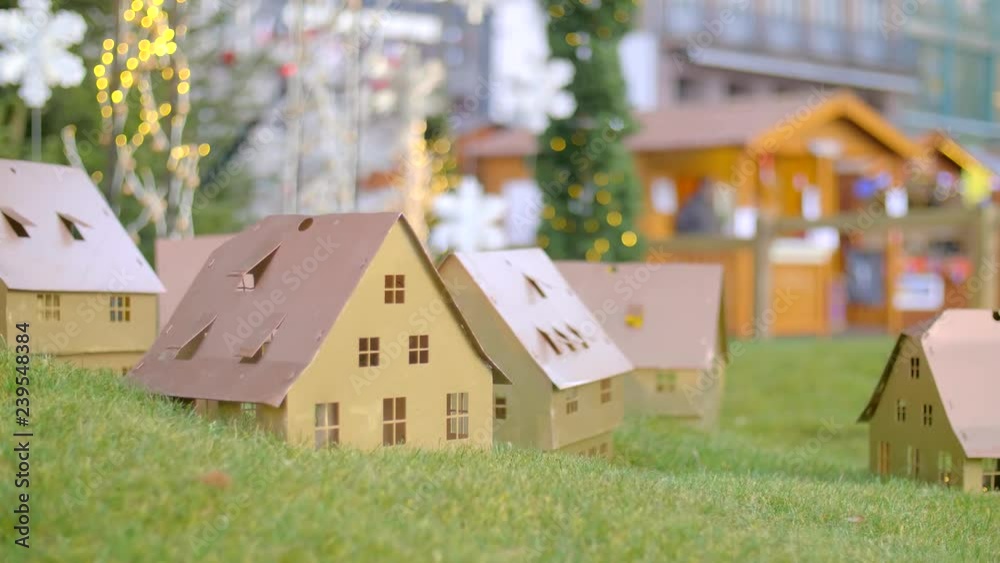 Handmade small white folded cardboard houses with illuminated windows on gren lawn background. Winter decoration. Christmas, Architecture and business real estate concept. Handmade small white folded cardboard houses with illuminated windows on gren lawn background. Winter decoration. Christmas, Architecture and business real estate concept.
