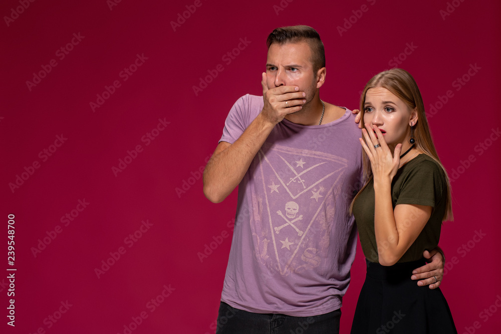 Unhappy discontent woman and man look with disgusting expression, as see something unpleasant. Awkward couple