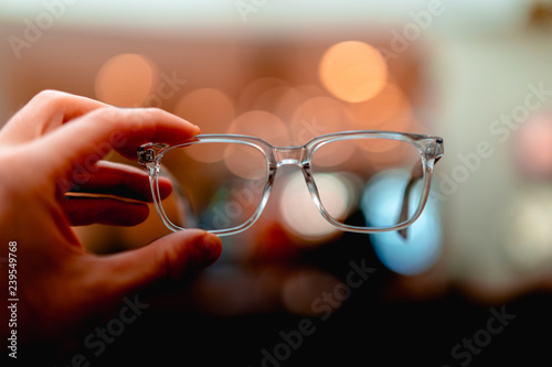 A pair of glasses with yellow bokeh in the background