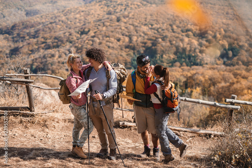 Group of hikers standing an looking at maps. Autumn time.
