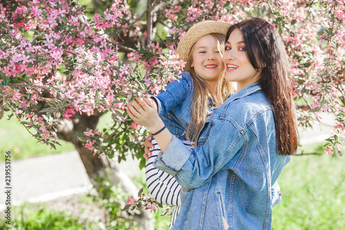 Young mother and her little daughter having fun in spring time. Beautiful mum and cute girl walking outdoor. Happy family together