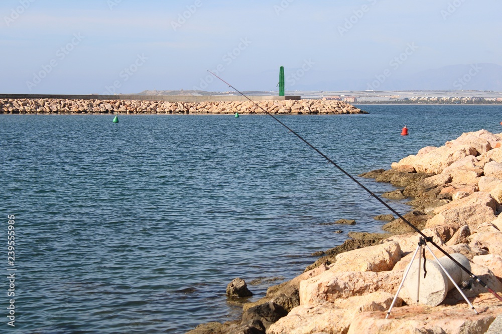 Stone jetty and fishing rod