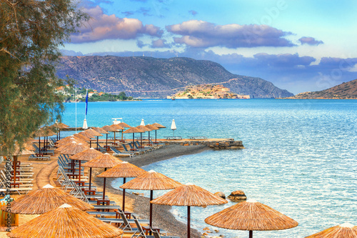 Panoramic view of the gulf of Elounda with the famous village of Elounda and the island of Spinalonga at sunset with nice clouds and calm sea, Crete, Greece.