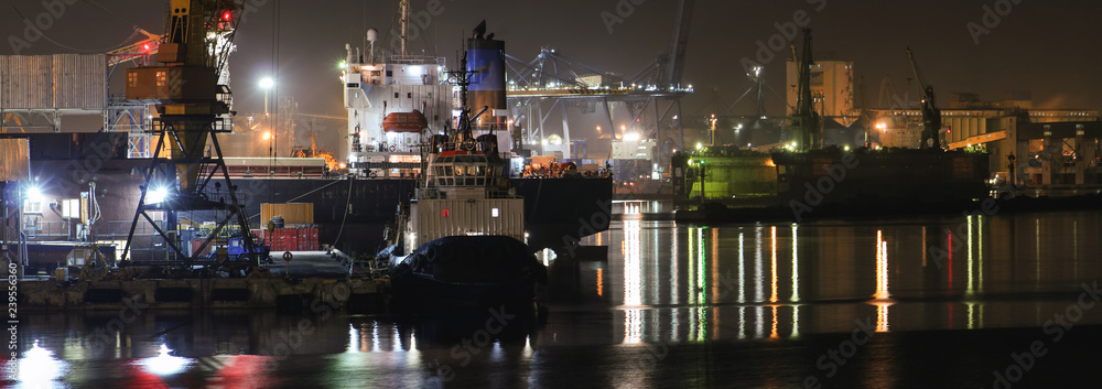 Loading grain in the port. Night panoramic view of the port, cranes and other port infrastructure.