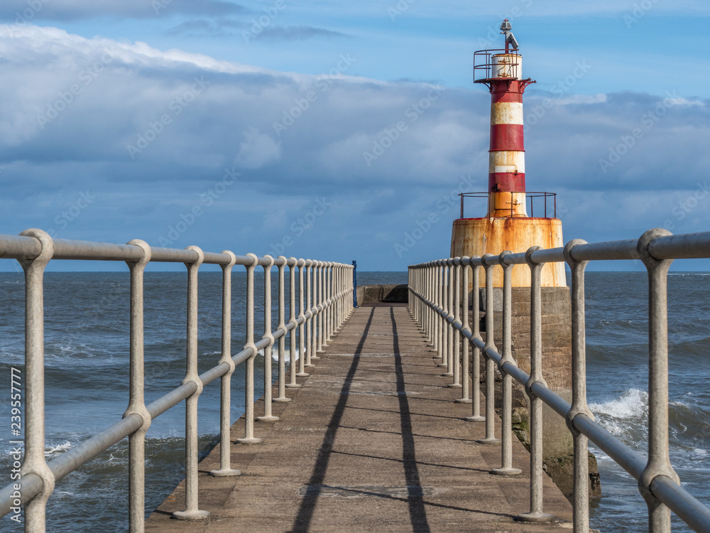 Lighthouse at the end of Amble pier, Northumberland, at the entrance to Amble Harbour