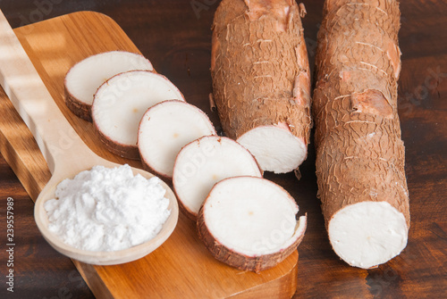 Raw cassava tuber on wooden background - Manihot esculenta photo