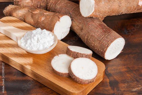 Raw cassava tuber on wooden background - Manihot esculenta