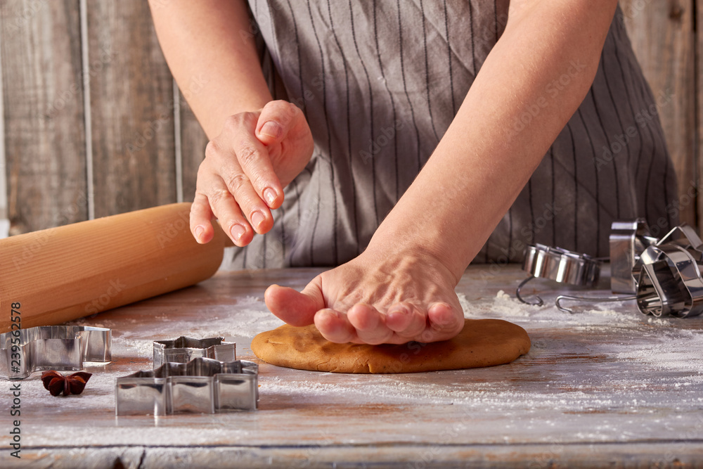Woman hands rolls up the gingerbread dough on the table