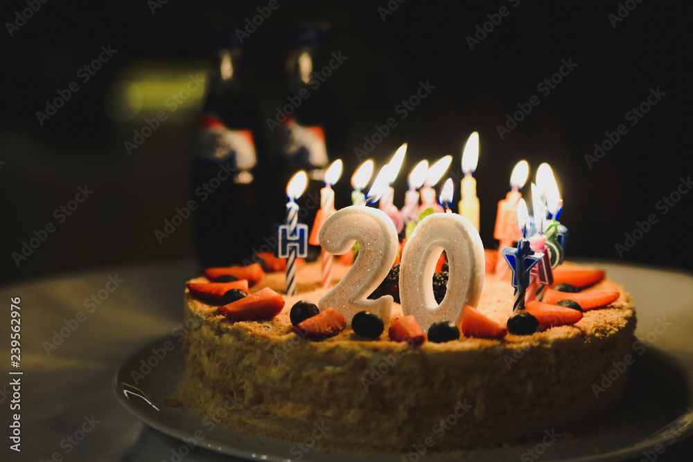 Cream cake and number 20 candle on top. Selective focus