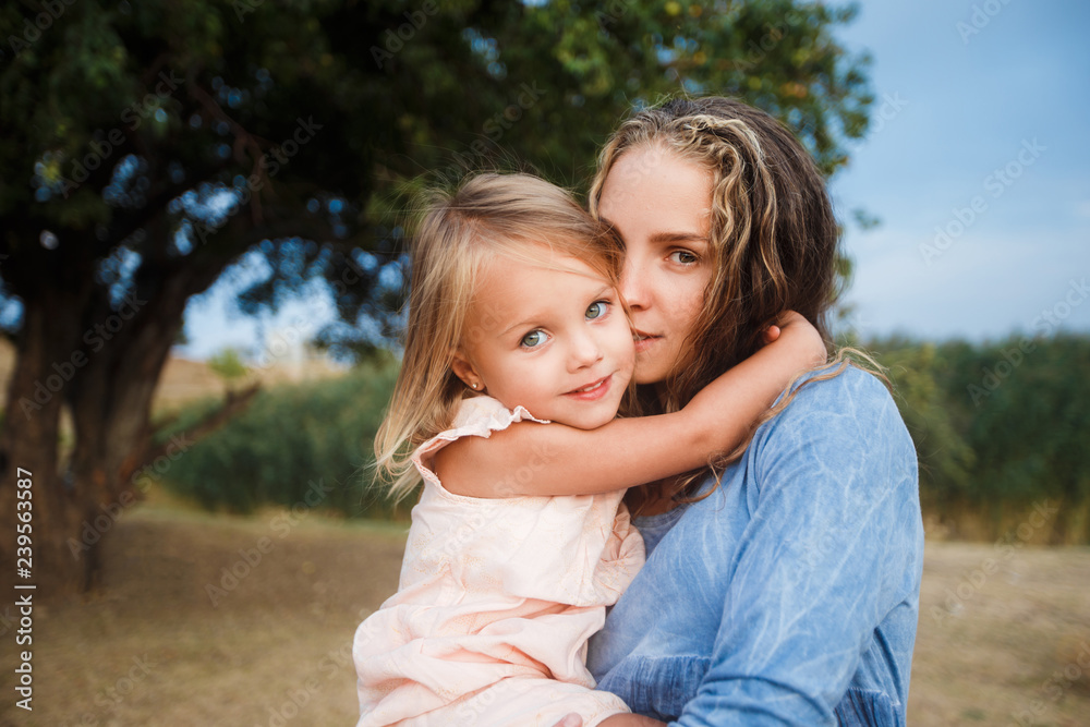 Сurly mother and child are hugging and having fun outdoor in nature Сurly mother and child are hugging and having fun outdoor in nature
