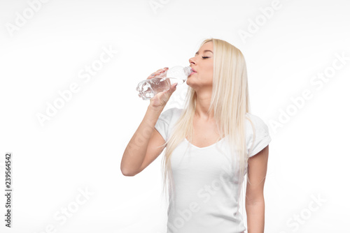 Healthy blond woman holding and drink glass of pure water on isolated white background